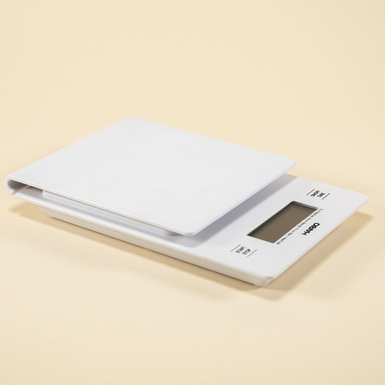 White plastic rectangular shaped scale with digital screen and set against a light background.