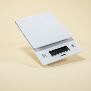 White plastic rectangular shaped scale with digital screen and set against a light background.