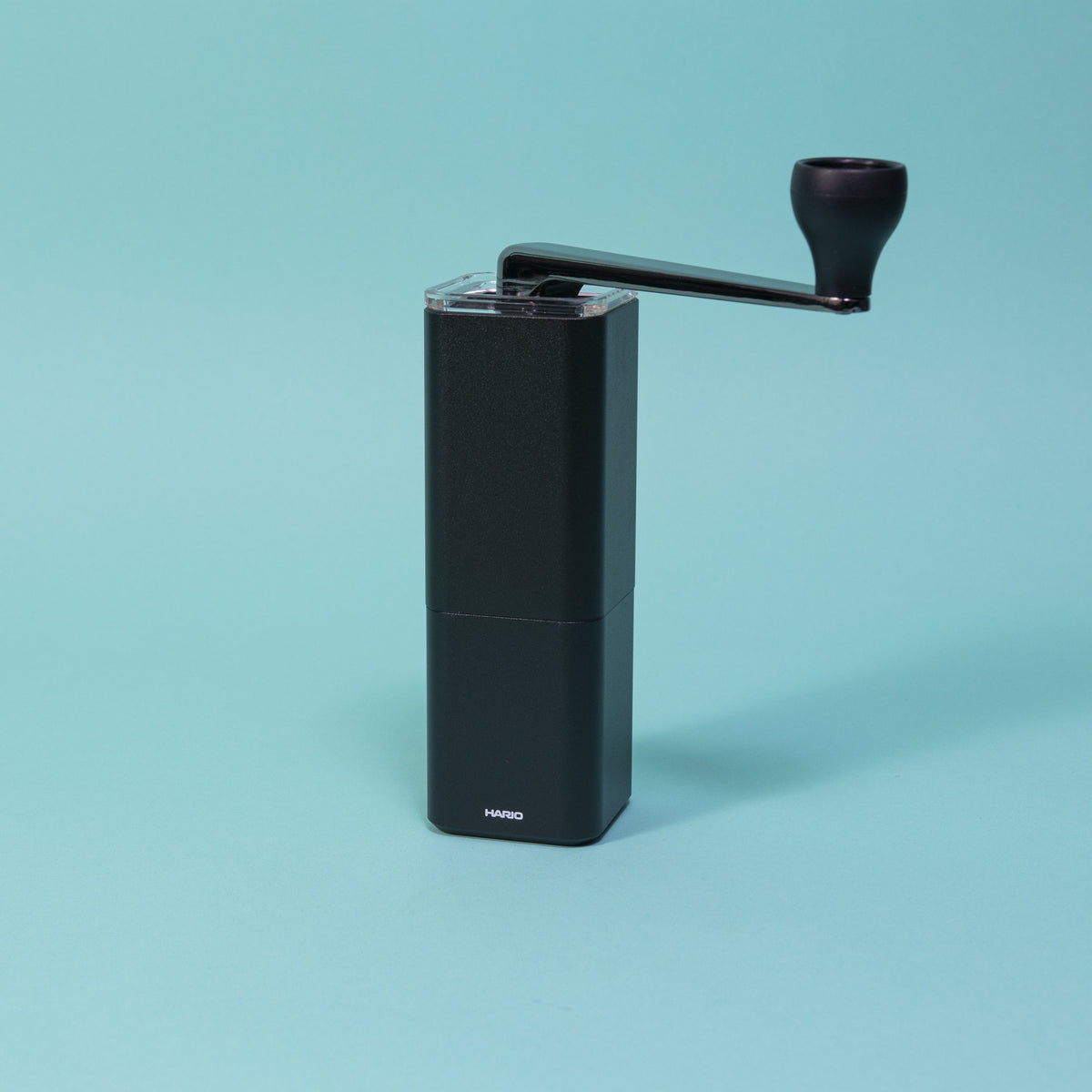 Black metal monolithic grinder with clear lid and black chromed handle.