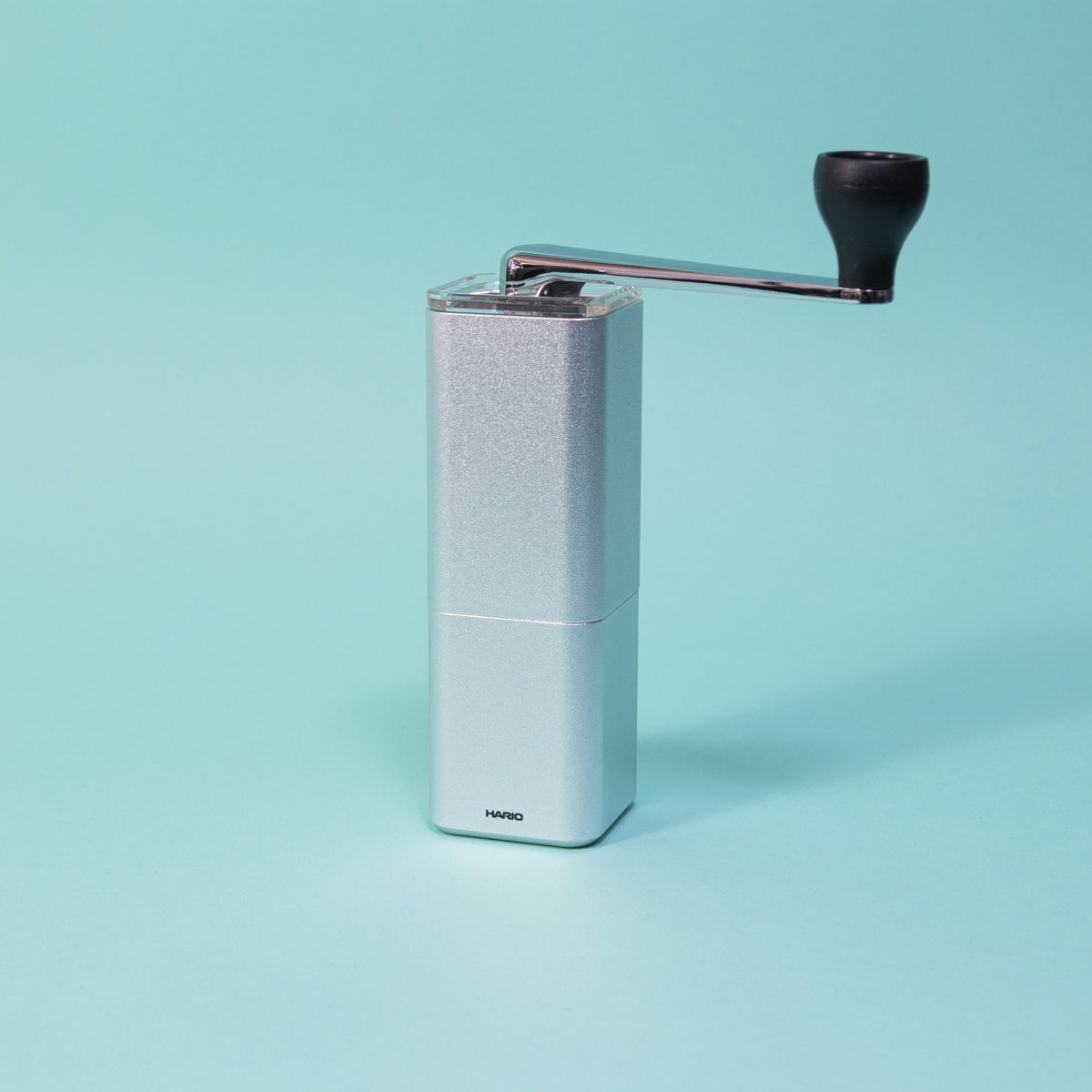 Silver monolithic grinder with clear lid and chrome handle.