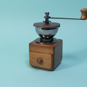 Wooden cube and drawer with dark metal grinder hopper and handle on top