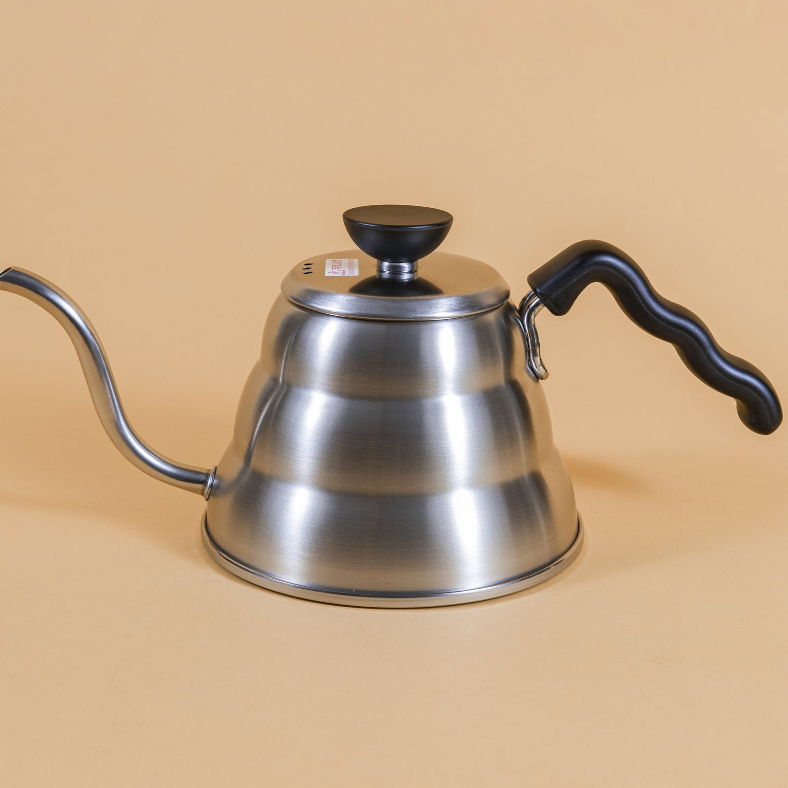 Short stainless steel gooseneck kettle and matching lid with plastic knob and black plastic covered handle.