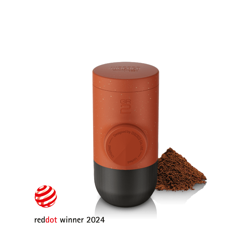 Wacaco Minipresso GR2 portable espresso maker in Tuscan Red with ground coffee, Red Dot Design Award winner 2024