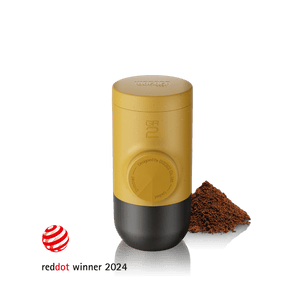 Wacaco Minipresso GR2 portable espresso maker in Amber Yellow with ground coffee, Red Dot Design Award winner 2024